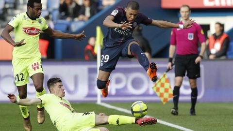 PSG's Kylian Mbappe jumps over Angers' Baptiste Santamaria as Angers' Lassana Coulibaly looks on during the French League One soccer match between Paris Saint-Germain and Angers at the Parc des Princes Stadium, in Paris, France, Wednesday, March 14, 2018. (AP Photo/Christophe Ena)
