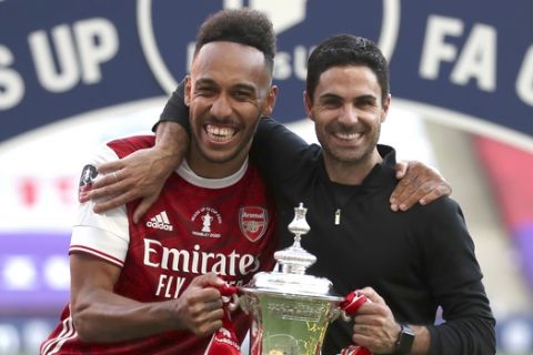Arsenal's head coach Mikel Arteta and Arsenal's Pierre-Emerick Aubameyang pose with the trophy after the FA Cup final soccer match between Arsenal and Chelsea at Wembley stadium in London, England, Saturday, Aug.1, 2020. (Catherine Ivill/Pool via AP)