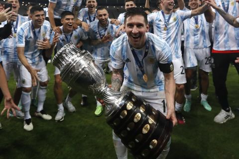 Argentina's Lionel Messi celebrates with the trophy after beating Brazil 1-0  in the Copa America final soccer match at the Maracana stadium in Rio de Janeiro, Brazil, Saturday, July 10, 2021. (AP Photo/Bruna Prado)