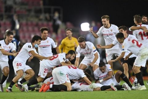 Sevilla players celebrate after the Europa League final soccer match between Sevilla and Inter Milan at the Rhein Energie Stadium in Cologne, Germany, Friday, Aug. 21, 2020. Sevilla won 3-2. (AP Photo/Martin Meissner, Pool)