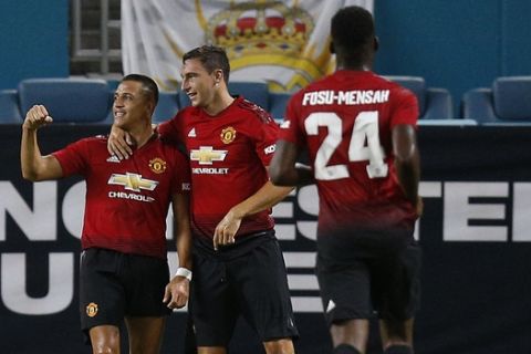 Manchester United midfielder Alexis Sanchez, left, celebrates his goal with teammates during the first half of the International Champions Cup tournament soccer match against Real Madrid, Tuesday, July 31, 2018, in Miami Gardens, Fla. (AP Photo/Brynn Anderson)