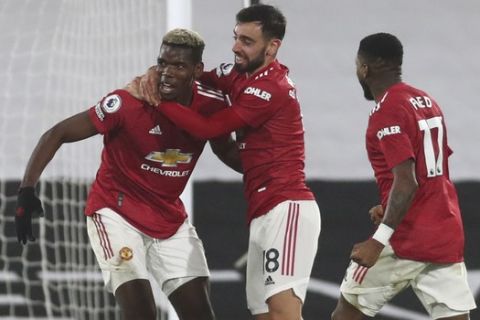 Manchester United's Paul Pogba, centre, celebrates with teammates after scoring his side's second goal during the English Premier League soccer match between Fulham and Manchester United at the Craven Cottage stadium in London, Wednesday, Jan. 20, 2021. (Clive Rose/Pool via AP)