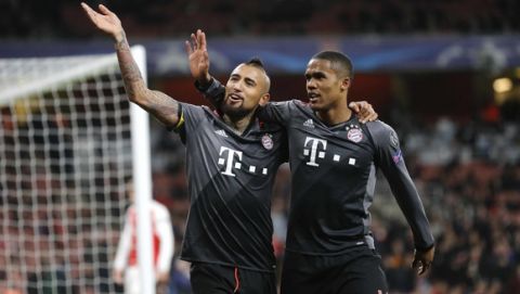 Bayern's Arturo Vidal, left, celebrates with Douglas Costa after scoring his side's fifth goal during the Champions League round of 16 second leg soccer match between Arsenal and Bayern Munich at the Emirates Stadium in London, Tuesday, March 7, 2017. (AP Photo/Frank Augstein)