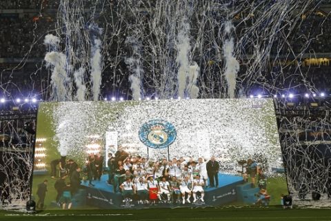 Real Madrid supporters watch on big screens placed at the team's Santiago Bernabeu stadium in Madrid, Spain, for the celebration of their team winning the Champions League final match against Liverpool played in Kiev, Ukraine, Saturday, May 26, 2018. Real Madrid won 3-1. (AP Photo/Francisco Seco)