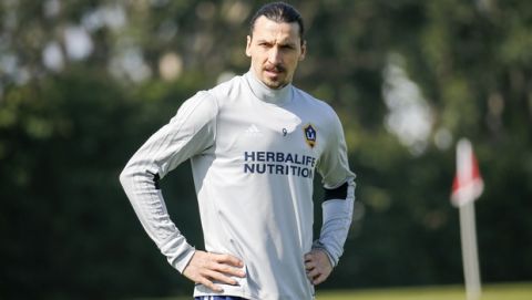LA Galaxy's newest player Zlatan Ibrahimovic, center, of Sweden, looks on as he warms up during an MLS soccer training session at the StubHub Center, Friday, March 30, 2018, in Carson, Calif. (AP Photo/Ringo H.W. Chiu)