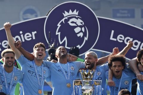 Manchester City players pose with the English Premier League trophy after the English Premier League soccer match against Brighton at the AMEX Stadium in Brighton, England, Sunday, May 12, 2019. Manchester City defeated Brighton to win the championship. (AP Photo/Frank Augstein)