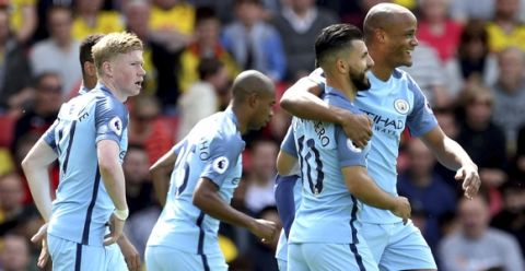 Manchester City's Vincent Kompany, background right, celebrates scoring the opening goal with teammate Sergio Aguero, during the English Premier League soccer match between Manchester City and Watford, at Vicarage Road, in Watford, England. (Steven Paston/PA/ via AP)