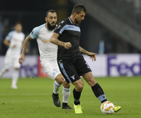 Lazio's Francesco Acerbi, right, challenges for the ball with Marseille's Konstantinos Mitroglou during the Europa League, Group H soccer match between Marseille and Lazio at the Velodrome Stadium in Marseille, France,Thursday, Oct. 25, 2018. (AP Photo/Claude Paris)