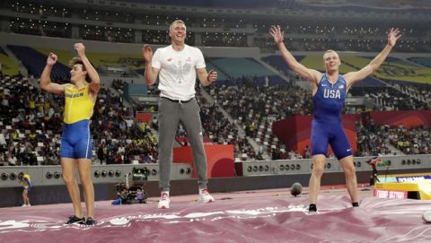 Armand Duplantis, left, of Sweden; Piotr Lisek, center, of Poland; and Sam Kendricks, right, of the United States; celebrate after the the men's pole vault final at the World Athletics Championships in Doha, Qatar, Tuesday, Oct. 1, 2019. (AP Photo/Hassan Ammar)