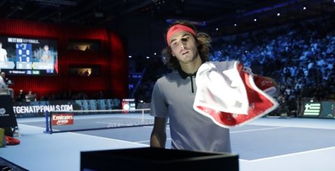 Stefanos Tsitsipas of Greece, handles his towel as he plays against Alex De Minaur of Australia, during the ATP Next Gen tennis tournament final, at the Rho fair, near Milan, Italy, Saturday, Nov. 10, 2018. During the event, featuring many of the innovations that debuted last year, players are instructed to use a towel rack at the back of the court to remove the onus on ball kids to handle towels. (AP Photo/Luca Bruno)