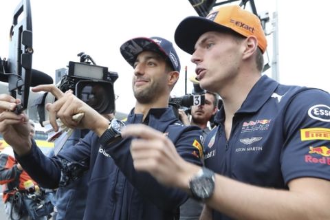 Red Bull driver Daniel Ricciardo, left, of Australia and his teammate Max Verstappen, right, of the Netherlands take selfie image during a fan meeting ahead of the Japanese Formula One Grand Prix at the Suzuka Circuit in Suzuka, central Japan Thursday, Oct. 5, 2017. (AP Photo/Eugene Hoshiko)