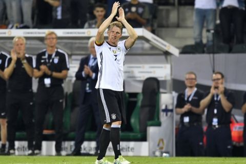 Germany's captain Bastian Schweinsteiger claps hands to the German fans for the last time while he leaves the pitch during a friendly soccer match between Germany and Finland in Moenchengladbach, Germany, Wednesday, Aug. 31, 2016. Schweinsteiger made his last match for the national team. (AP Photo/Martin Meissner)