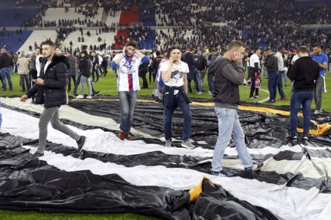 People invade the pitch a few minutes before the Europa League quarterfinal soccer match between Lyon and Besiktas, in Decines, near Lyon, central France, Thursday, April 13, 2017. (AP Photo/Laurent Cipriani)