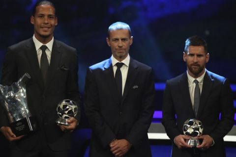 Dutch soccer player Virgil van Dijk of Liverpool, left, holds the award of men's player of the year 2018/19 as he pose with UEFA President Aleksander Ceferin, center, and Barcelona's soccer player Lionel Messi during the group stage draw at the Grimaldi Forum, in Monaco, Thursday, Aug. 29, 2019. (AP Photo/Daniel Cole)