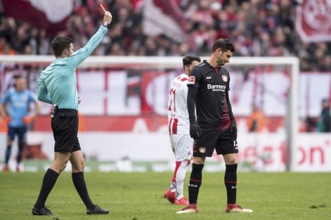 Referee Harm Osmers, left, shows the red card to Leverkusen's Lucas Alario, right,  during the German Bundesliga soccer match between 1. FC Cologne and Bayer Leverkusen in Cologne, Germany, Sunday, March 18, 2018. (Marius Becker/dpa via AP)