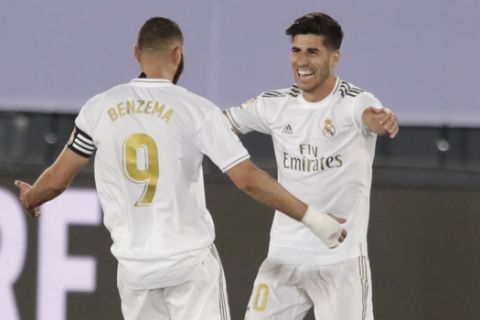 Real Madrid's Marco Asensio, right, celebrates hit his teammate Karim Benzema after scoring during the Spanish La Liga soccer match between Real Madrid and Deportivo Alaves at the Alfredo di Stefano stadium in Madrid, Spain, Friday, July 10, 2020. (AP Photo/Bernat Armangue)
