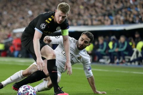 Manchester City's Kevin De Bruyne, left, duels for the ball with Real Madrid's Dani Carvajal during the Champions League, round of 16, first leg soccer match between Real Madrid and Manchester City at the Santiago Bernabeu stadium in Madrid, Spain, Wednesday, Feb. 26, 2020. (AP Photo/Manu Fernandez)