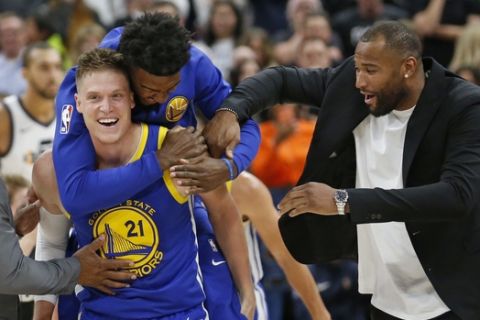 Golden State Warriors' Jonas Jerebko (21) celebrates after scoring the winning shot against the Utah Jazz, with teammates Jordan Bell, rear, and DeMarcus Cousins, right, in the second half during an NBA basketball game Friday, Oct. 19, 2018, in Salt Lake City. (AP Photo/Rick Bowmer)