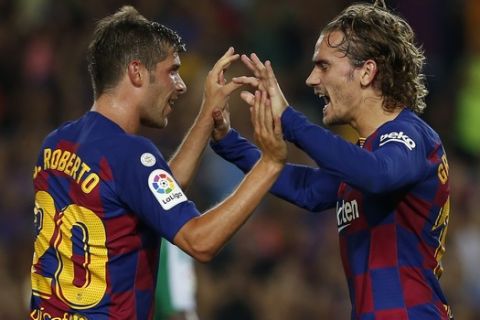 Barcelona's Antoine Griezmann, right, celebrates after scoring with his teammate Barcelona's Sergi Roberto his side's first goal during the Spanish La Liga soccer match between FC Barcelona and Betis at the Camp Nou stadium in Barcelona, Spain, Sunday, Aug. 25, 2019. (AP Photo/Joan Monfort)