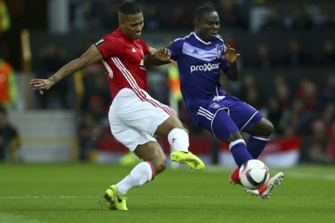 Manchester United's Antonio Valencia, left, competes for the ball with Anderlecht's Frank Acheampong during the Europa League quarterfinal second leg soccer match between Manchester United and Anderlecht at Old Trafford stadium, in Manchester, England, Thursday, April 20, 2017. (AP Photo/Dave Thompson)