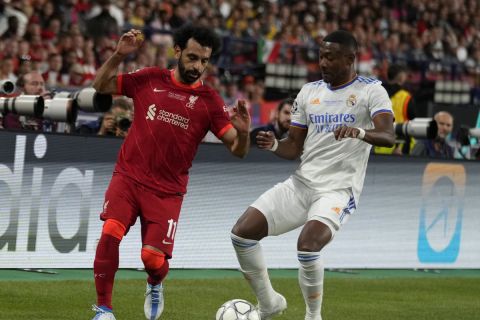 Liverpool's Mohamed Salah, left, is challenged by Real Madrid's David Alaba during the Champions League final soccer match between Liverpool and Real Madrid at the Stade de France in Saint Denis near Paris, Saturday, May 28, 2022. (AP Photo/Kirsty Wigglesworth)