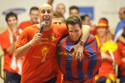 Spain's goalkeeper Pepe Reina (L) holds Spain's midfielder Cesc Fabregas wearing Barcelona's jersey as they celebrate on a stage set up for the Spanish team victory ceremony in Madrid on July 12, 2010 a day after they won the 2010 FIFA football World Cup match against the Netherlands in Johannesburg.      AFP PHOTO / MIGUEL RIOPA    (Photo credit should read MIGUEL RIOPA/AFP/Getty Images)