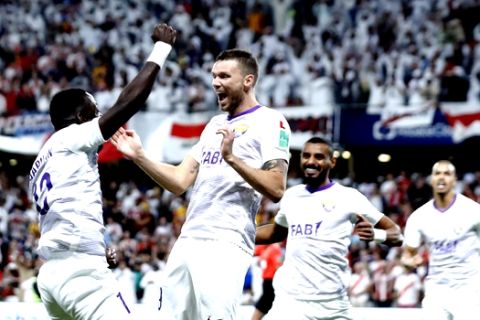 Emirates's Al Ain Marcus Berg, second left, celebrates with Emirates's Al Ain Ahmed Barman, left, after Argentina's River Plate Javier Pinola scores an own goal during the Club World Cup semifinal soccer match between Al Ain Club and River Plate at the Hazza Bin Zayed stadium in Al Ain, United Arab Emirates, Tuesday, Dec. 18, 2018. (AP Photo/Hassan Ammar)