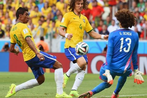 FORTALEZA, BRAZIL - JUNE 17:  Paulinho of Brazil shoots against Guillermo Ochoa of Mexico as David Luiz runs on during the 2014 FIFA World Cup Brazil Group A match between Brazil and Mexico at Castelao on June 17, 2014 in Fortaleza, Brazil.  (Photo by Laurence Griffiths/Getty Images)