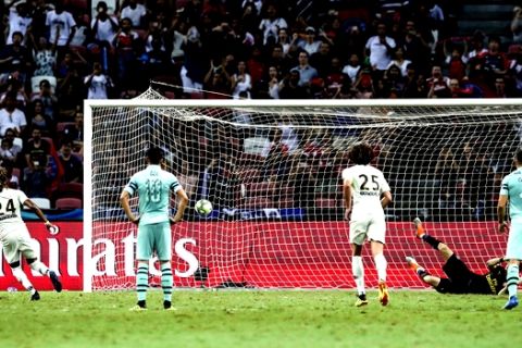 Paris Saint-Germain's Christopher Nkunku, left, scores a penalty during the International Champions Cup match between Arsenal and Paris Saint-Germain in Singapore, Saturday, July 28, 2018. (AP Photo/Yong Teck Lim)