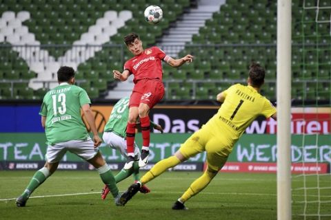 Leverkusen's Kai Havertz, center, scores the opening goal during the German Bundesliga soccer match between Werder Bremen and Bayer Leverkusen 04 in Bremen, Germany, Monday, May 18, 2020. The German Bundesliga becomes the world's first major soccer league to resume after a two-month suspension because of the coronavirus pandemic. (AP Photo/Stuart Franklin, Pool)