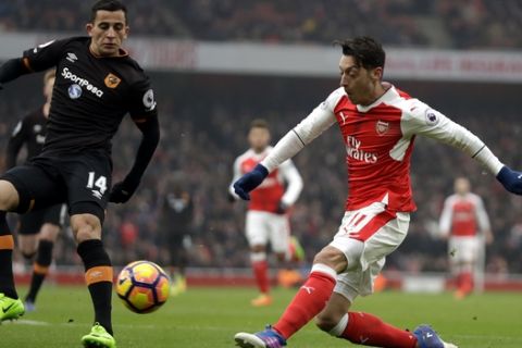 Arsenal's Mezut Ozil, right, competes for the ball with Hull City's Omar Elabdellaoui during the English Premier League soccer match between Arsenal and Hull City at the Emirates Stadium in London, Saturday, Feb. 11, 2017. (AP Photo/Matt Dunham)