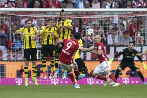 Munich's Robert Lewandowski, front, scores his side's 2nd goal during the German Bundesliga soccer match between FC Bayern Munich and Borussia Dortmund in Munich, Germany, Saturday, April8, 2017. (Sven Hoppe/dpa via AP)