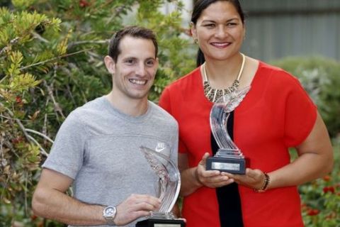French Olympic pole vault champion and world record holder Renaud Lavillenie (L) and New Zealander shot put champion Valerie Adams (R) pose with their awards ahead of the IAAF World Athlete of the Year gala in Monaco on November 21, 2014. AFP PHOTO / VALERY HACHE