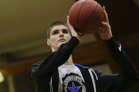 In this Saturday, Dec. 5, 2015, photo, Robert Bobroczkyi prepares to shoot a basketball during an interview in Rome. Standing 7-foot-6 (2.29 meters) at the age of 15, Robert Bobroczkyi is already taller than New York Knicks sensation Kristaps Porzingis, or any other current NBA player.  (AP Photo/Andrew Medichini)