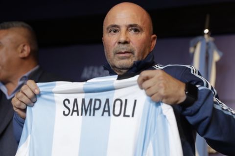 Argentina's new soccer coach Jorge Sampaoli holds up a jersey featuring his name at the end of a press conference in Buenos Aires, Argentina, Thursday, June 1, 2017. (AP Photo/Natacha Pisarenko)