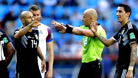 Argentina's Javier Mascherano, left, argues with Referee Szymon Marciniak of Poland during the group D match between Argentina and Iceland at the 2018 soccer World Cup in the Spartak Stadium in Moscow, Russia, Saturday, June 16, 2018. (AP Photo/Victor Caivano)