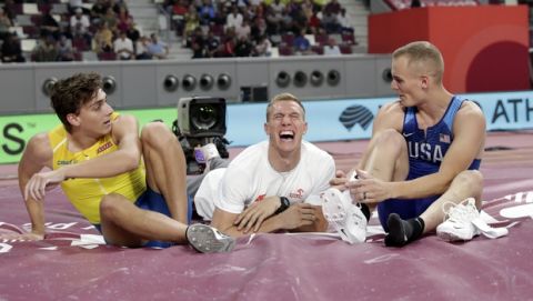 Armand Duplantis, left, of Sweden; Piotr Lisek, center, of Poland; and Sam Kendricks, right, of the United States; relax after the the men's pole vault final at the World Athletics Championships in Doha, Qatar, Tuesday, Oct. 1, 2019. (AP Photo/Hassan Ammar)
