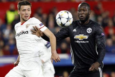 Manchester United's Romelu Lukaku fights for the ball with Sevilla's Clement Lenglet, left, during the Champions League round of sixteen first leg soccer match between Sevilla FC and Manchester United at the Ramon Sanchez Pizjuan stadium in Seville, Spain, Wednesday, Feb. 21, 2018. (AP Photo/Miguel Morenatti)