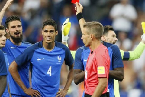 France's Raphael Varane, center left, gets the red card from referee Davide Massa during a friendly soccer match between France and England at the Stade de France in Saint Denis, north of Paris, France, Tuesday, June 13, 2017. (AP Photo/Francois Mori)