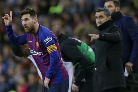 FC Barcelona's Lionel Messi, left, gestures next to his coach Ernesto Valverde during the Spanish La Liga soccer match between FC Barcelona and Valencia at the Camp Nou stadium in Barcelona, Spain, Saturday, Feb. 2, 2019. (AP Photo/Manu Fernandez)