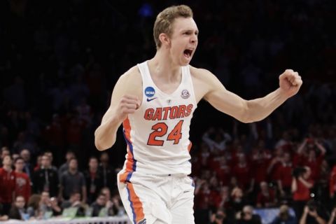 Florida guard Canyon Barry (24) reacts after Florida beat Wisconsin on a last second shot by guard Chris Chiozza (11) in overtime of an East Regional semifinal game of the NCAA men's college basketball tournament, Saturday, March 25, 2017, in New York. Florida won 84-83. (AP Photo/Frank Franklin II)