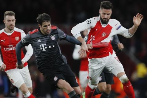 Arsenal's Olivier Giroud, right, is challenged by Bayern's Javi Martinez during the Champions League round of 16 second leg soccer match between Arsenal and Bayern Munich at the Emirates Stadimum in London, Tuesday, March 7, 2017. (AP Photo/Kirsty Wigglesworth)