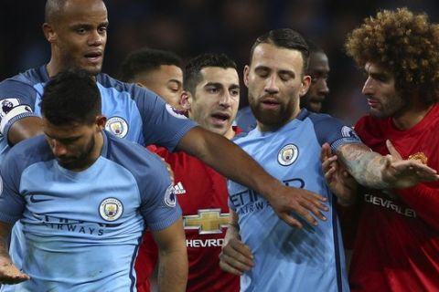 Manchester United's Marouane Fellaini, right, argues with Manchester City's Sergio Aguero, left, during the English Premier League soccer match between Manchester City and Manchester United at the Etihad Stadium in Manchester, England,Thursday, April 27, 2017.(AP Photo/Dave Thompson)