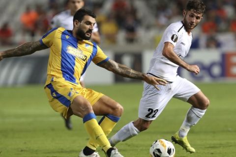 APOEL's Giorgos Merkis, left, fights for the ball with Dudelange's Antoine Bernier during the Europa League group A soccer match between APOEL Nicosia and Dudelange at GSP stadium in Nicosia, Cyprus, Thursday, Sept. 19, 2019. (AP Photo/Petros Karadjias)