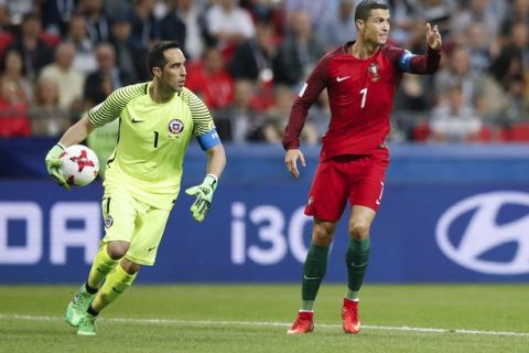 Portugal's Cristiano Ronaldo, right, gestures next to Chile goalkeeper Claudio Bravo during the Confederations Cup, semifinal soccer match between Portugal and Chile, at the Kazan Arena, Russia, Wednesday, June 28, 2017. (AP Photo/Pavel Golovkin)