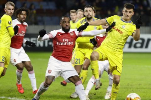 Arsenal's Alexandre Lacazette, front center, duels for the ball with Bate's Stanislav Dragun during the Europa League round of 32 first leg soccer match between Bate and Arsenal at the Borisov-Arena in Borisov, Belarus, Thursday, Feb. 14, 2019. (AP Photo/Sergei Grits)