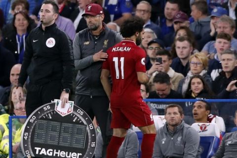 Liverpool manager Juergen Klopp, center, touches Liverpool's Mohamed Salah, as he is replaced by Liverpool's Xherdan Shaqiri, not seen, during the English Premier League soccer match between Chelsea and Liverpool at Stamford Bridge stadium in London, Saturday, Sept. 29, 2018. (AP Photo/Frank Augstein)