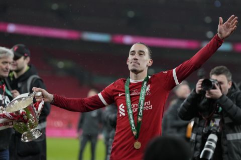 Liverpool's Kostas Tsimikas celebrates with the trophy after winning the English League Cup final soccer match between Chelsea and Liverpool at Wembley Stadium in London, Sunday, Feb. 25, 2024. (AP Photo/Alastair Grant)