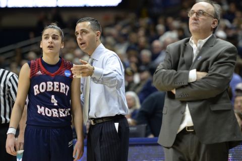 Associate head coach Charlie Buscaglia talks with player Anna Niki Stamolamprou, left, as father and head coach Sal Buscaglia, right, stands nearby during the second half of a first-round women's college basketball game in the NCAA Tournament, Saturday, March 19, 2016, in Storrs, Conn. This was Sal Buscaglia's last game as coach.  His son will take over next season. (AP Photo/Jessica Hill)