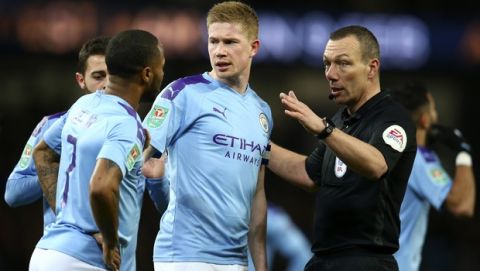 Referee Kevin Friend gestures to Manchester City players Bernardo Silva, Raheem Sterling and Kevin De Bruyne, from left, appealing for a penalty shot during the English League Cup semifinal second leg soccer match between Manchester City and Manchester United at Etihad stadium in Manchester, England, Wednesday, Jan. 29, 2020. (AP Photo/Dave Thompson)